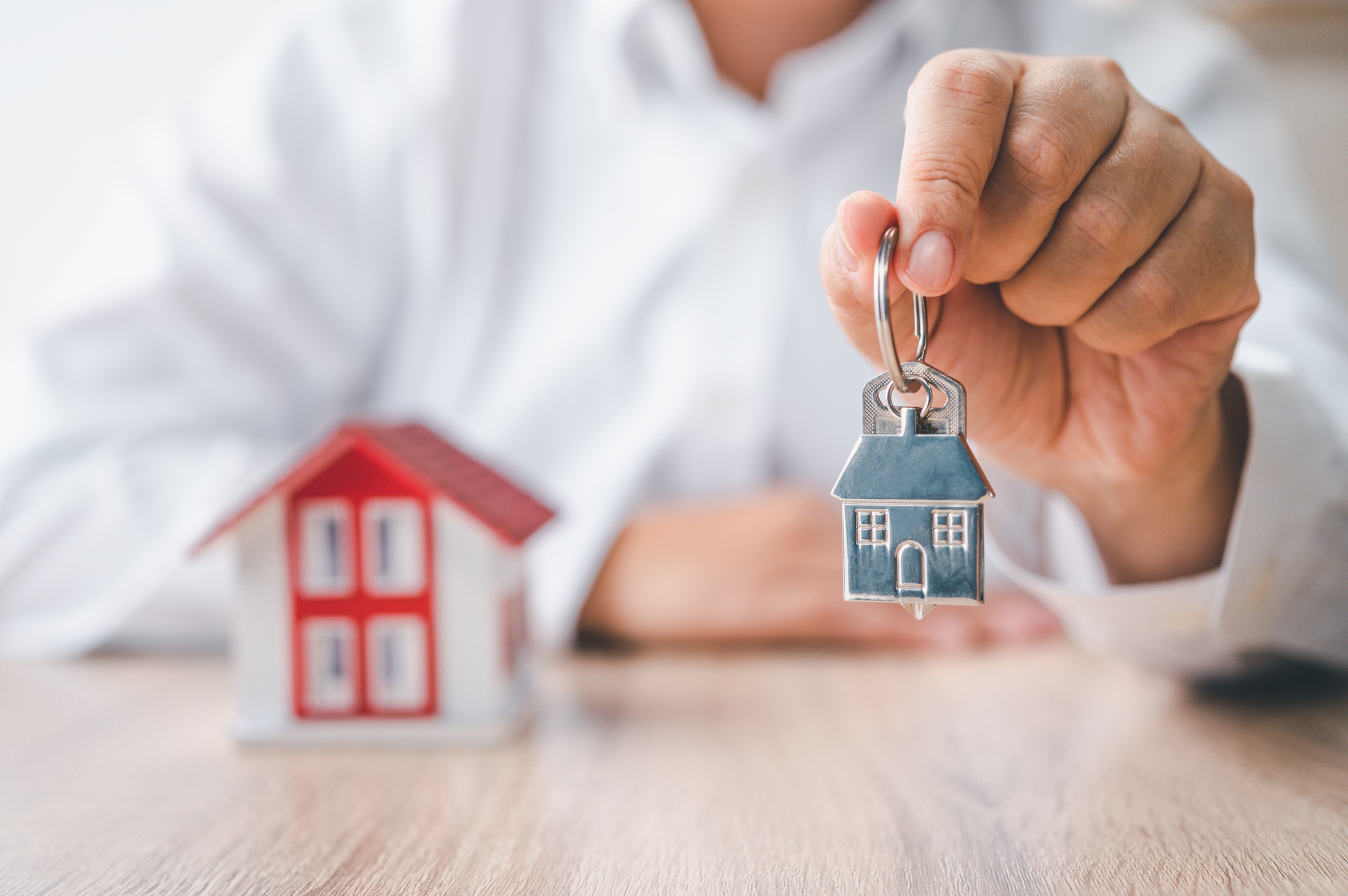 Concept of holding house keys, house keys for a new home, new home buying