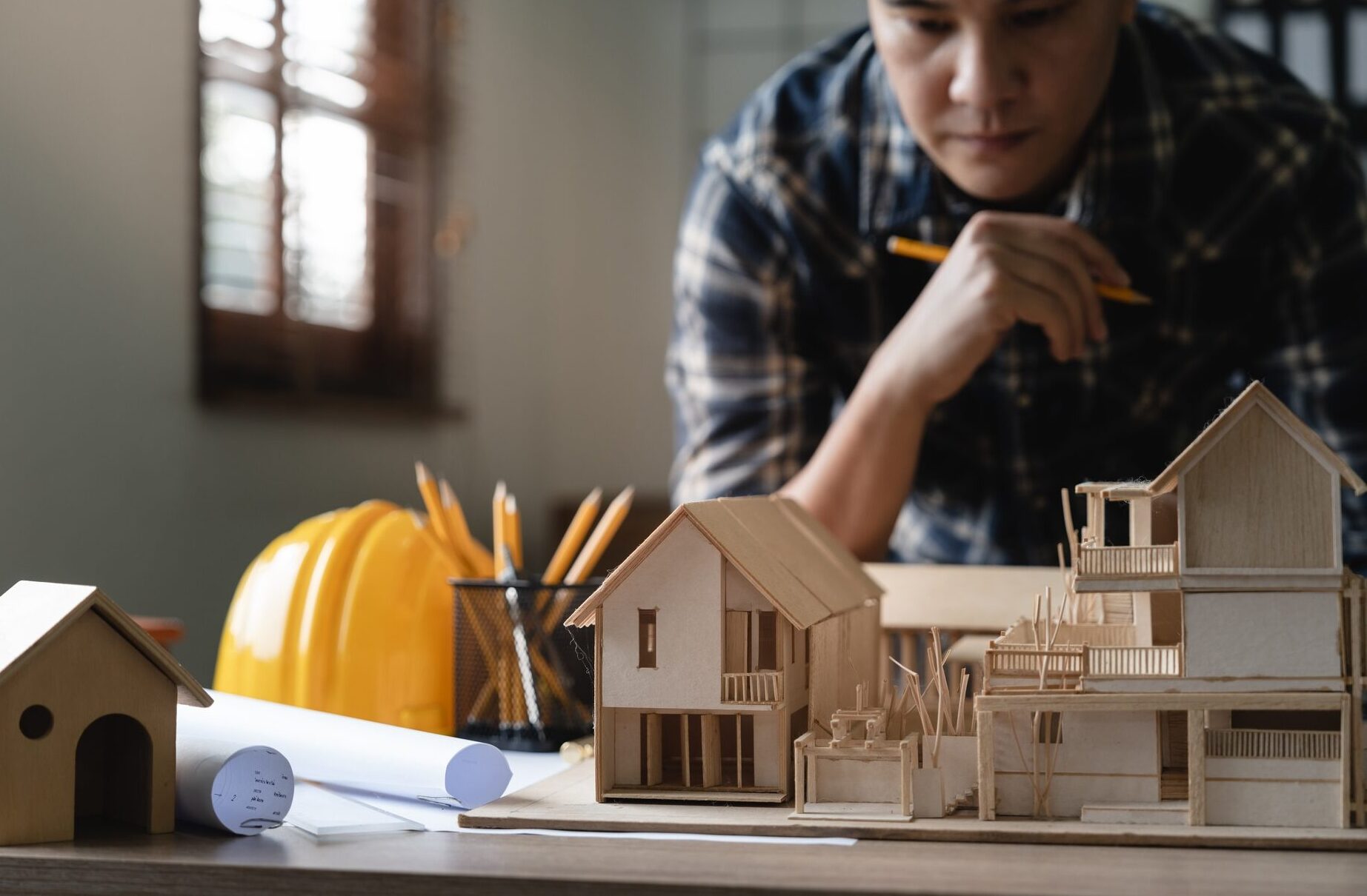 Engineer architect designer freelance work on start-up project with home model, construction plan