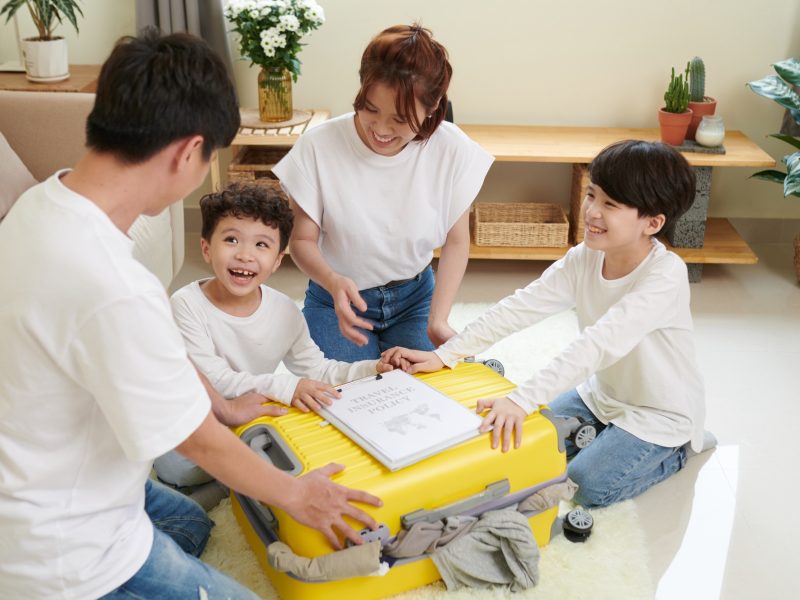 Family of Four Closing Packed Suitcase
